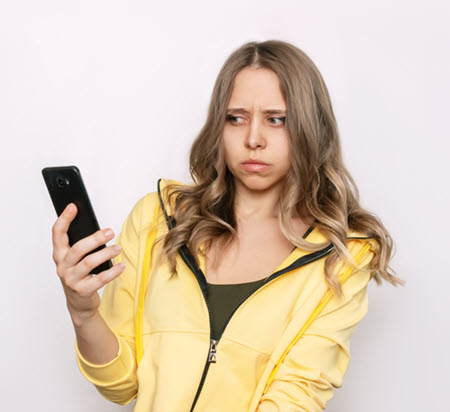 Image of woman looking at her phone with a suspicious look on her face